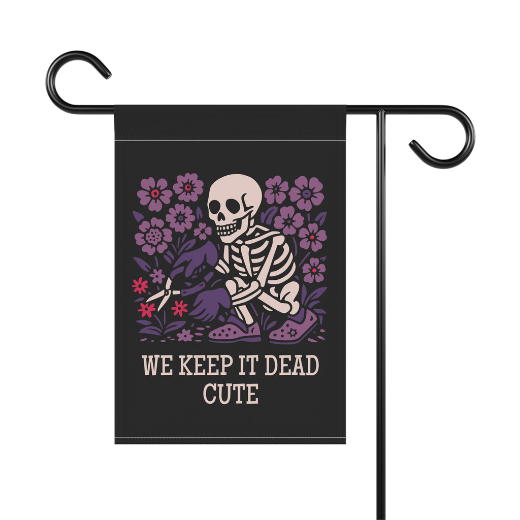 Garden flag with skeleton and flowers design and text 'WE KEEP IT DEAD CUTE' on a black background.