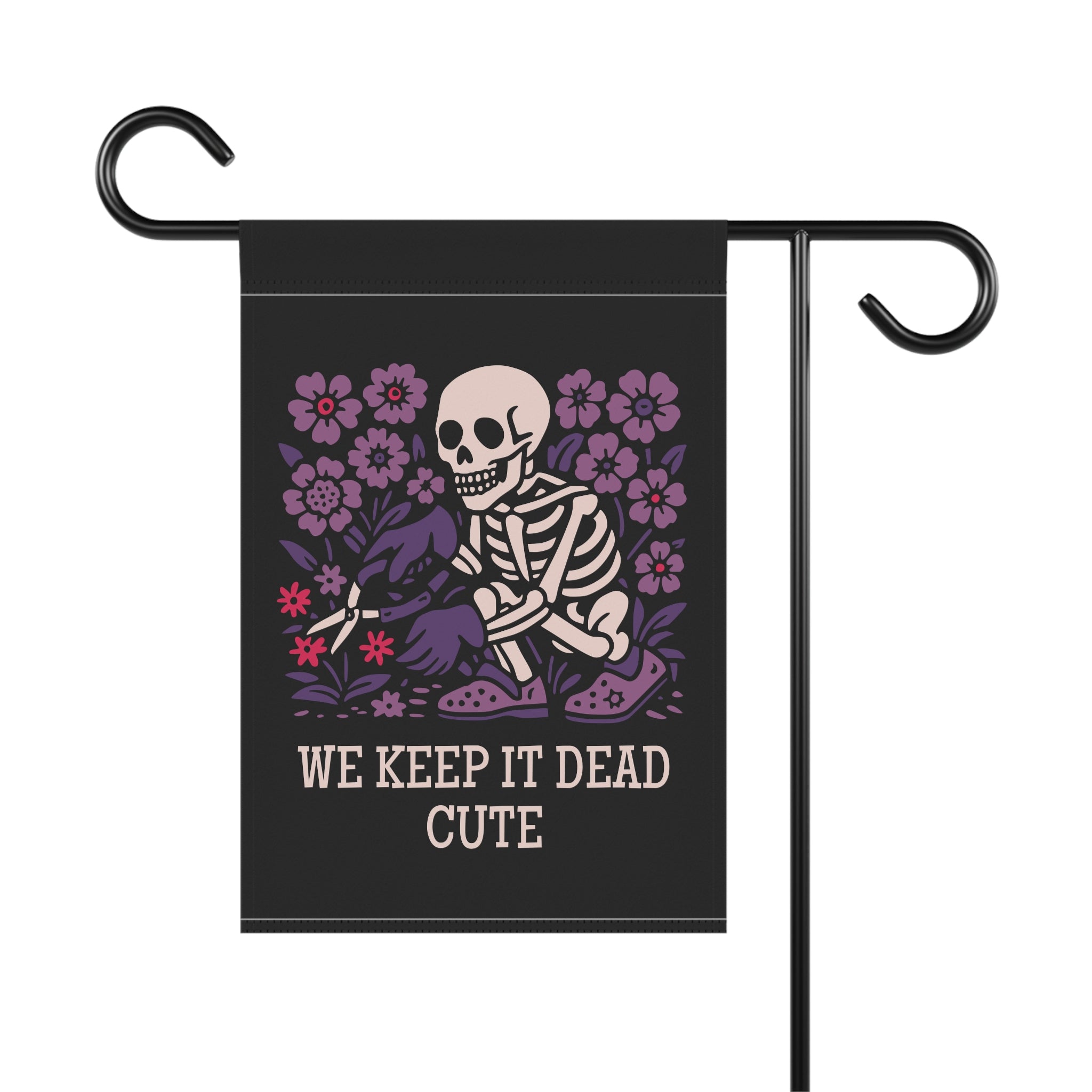 Garden flag with skeleton and flowers design and text 'WE KEEP IT DEAD CUTE' on a black background.