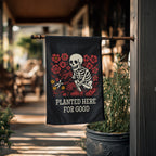 Decorative flag with skeleton and flowers design hanging outdoors.