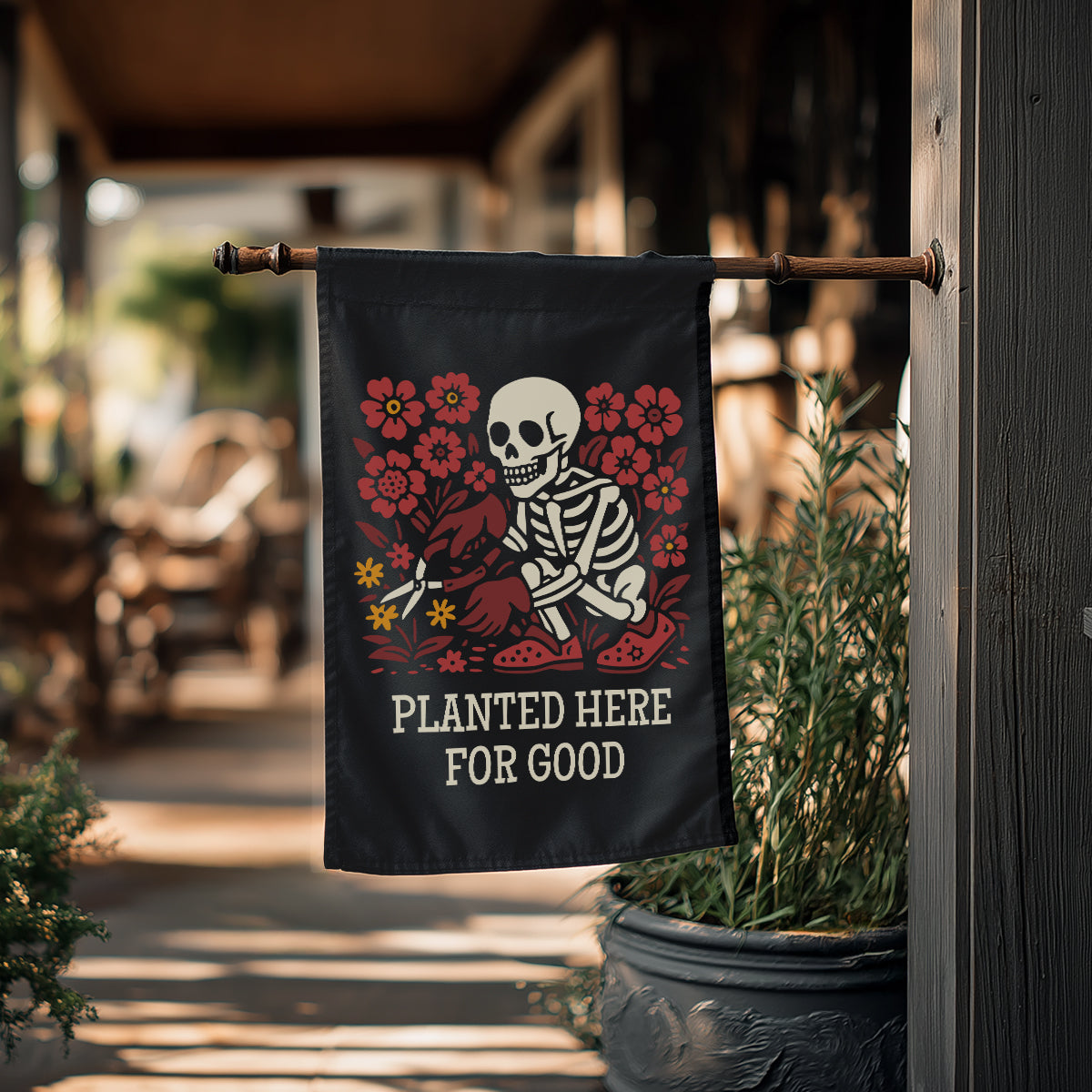 Decorative flag with skeleton and flowers design hanging outdoors.