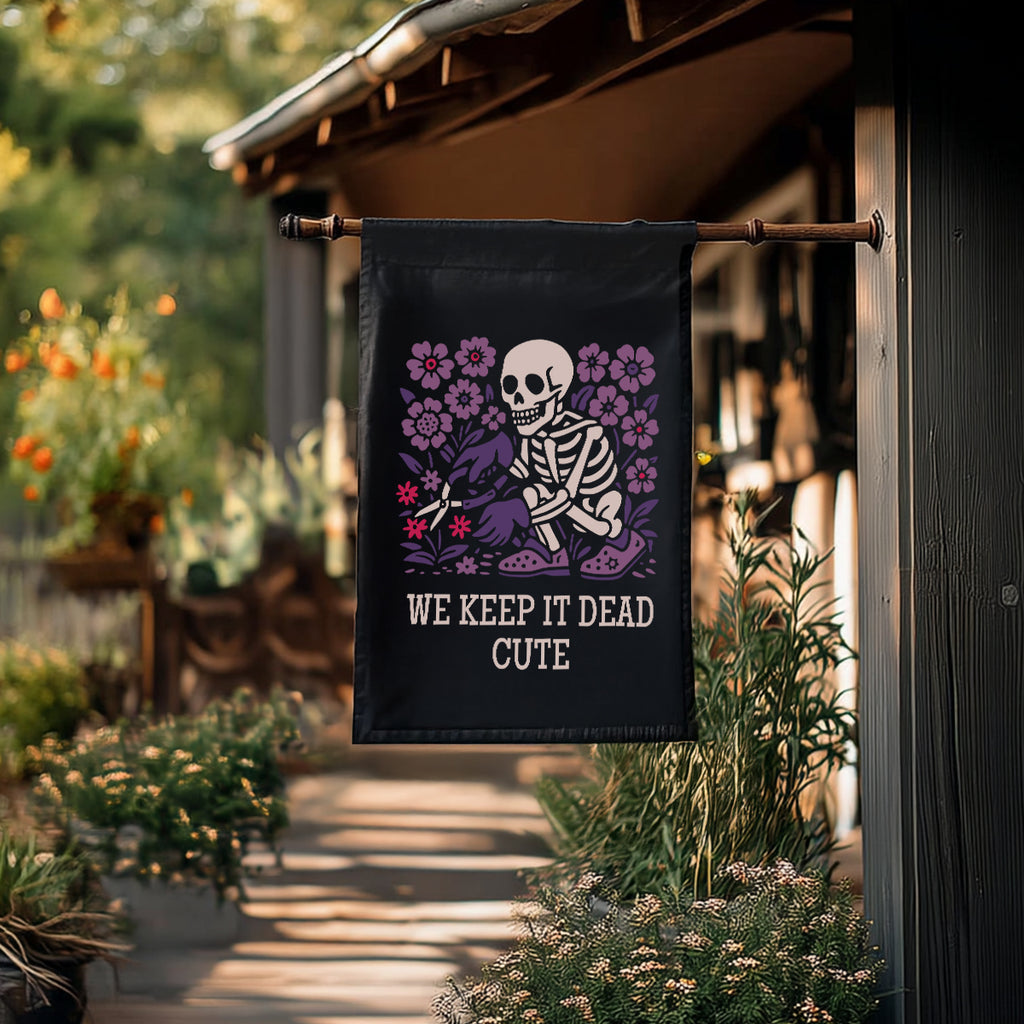 Decorative garden flag with skeleton and flowers design hanging on a wooden post outdoors.