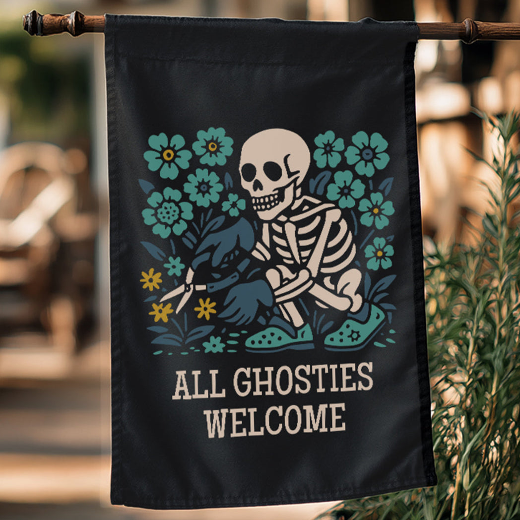 Decorative garden flag with a skeleton and floral design, featuring the text 'All Ghosties Welcome', hanging outdoors.