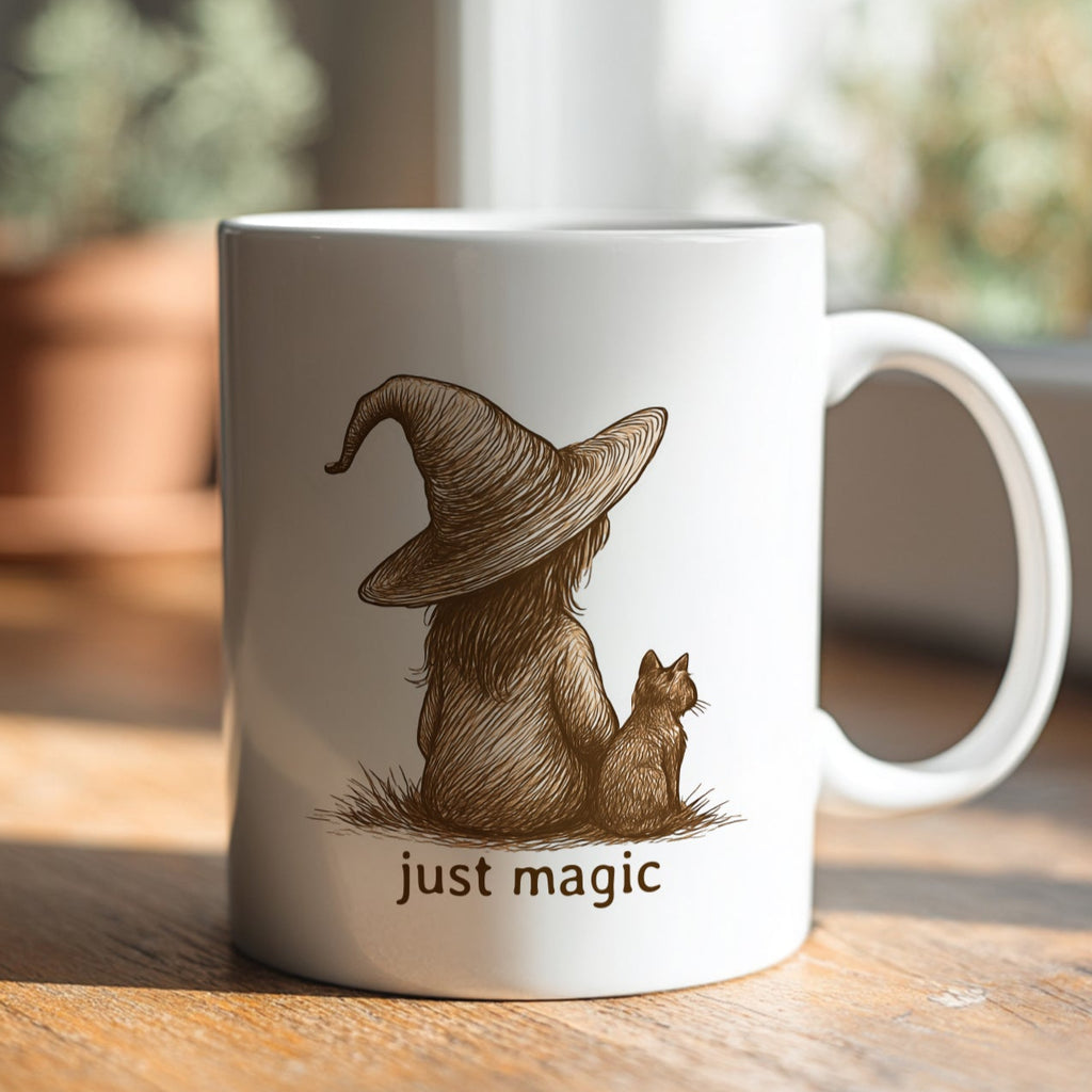 Mug with a design of a person in a witch hat with a cat and 'just magic' text on a wooden surface.