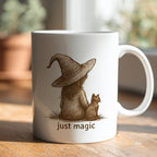 Mug with a design of a person in a witch hat with a cat and 'just magic' text on a wooden surface.
