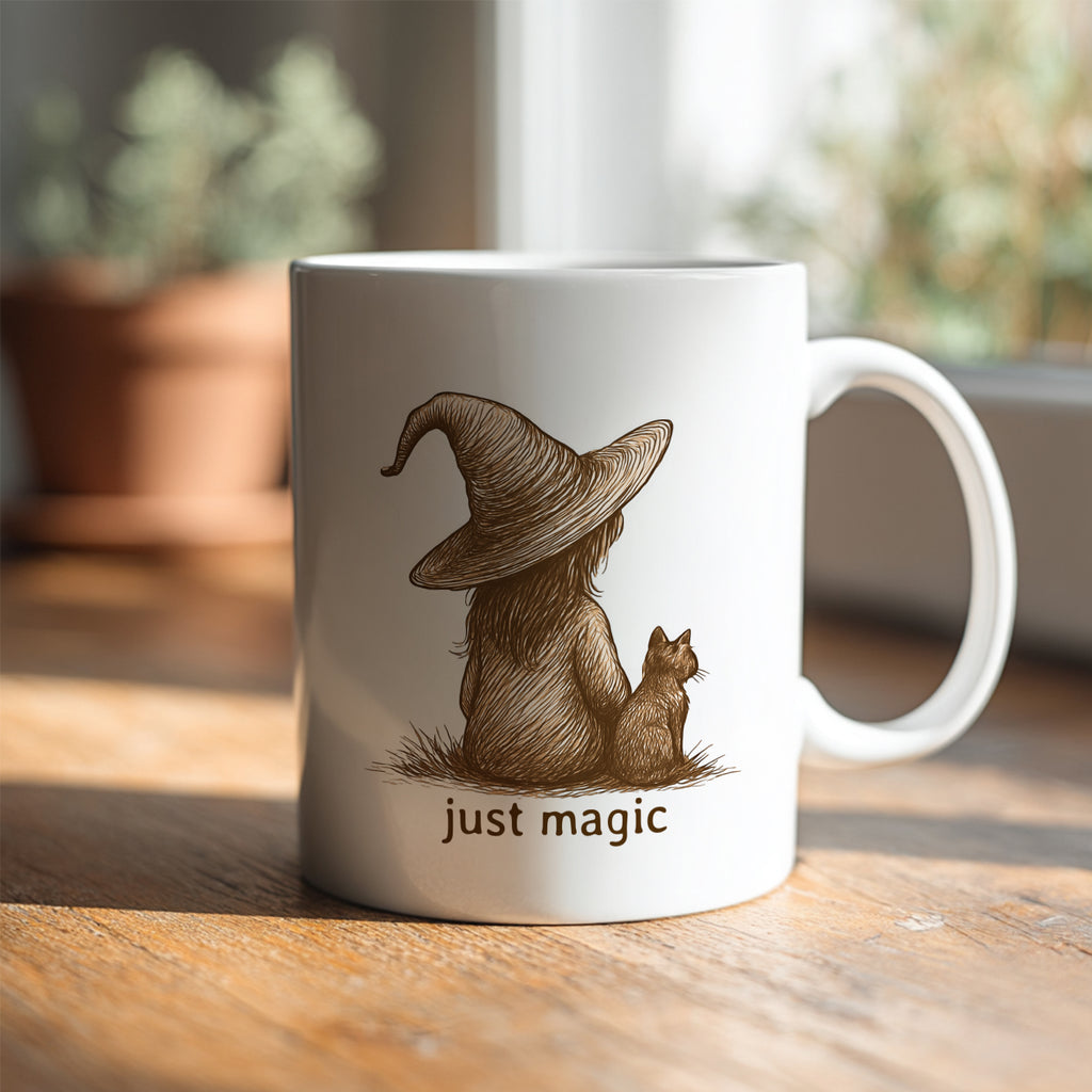 Mug with a design of a person in a witch hat with a cat and 'just magic' text on a wooden surface.