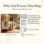 White ceramic mug with decorative design on a wooden surface, surrounded by autumn decor.
